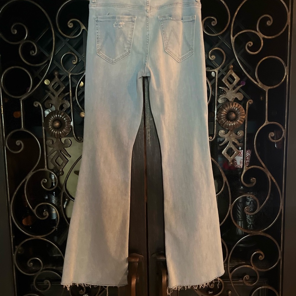 Mid-rise denim flare w/some stretch. Light blue wash with fading, & torn knees.